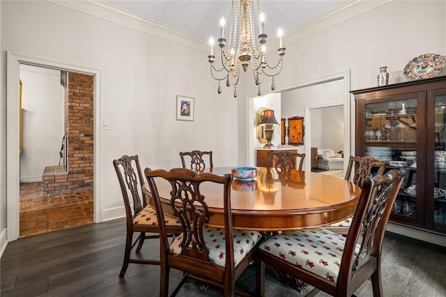 dining space featuring ornamental molding, dark wood-type flooring, and an inviting chandelier