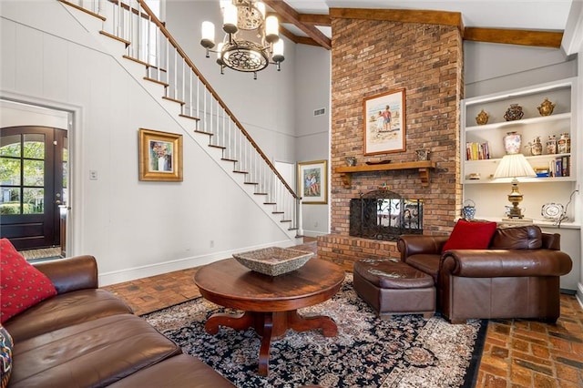 living room featuring beam ceiling, a fireplace, high vaulted ceiling, and an inviting chandelier