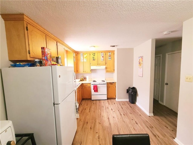 kitchen featuring a textured ceiling, under cabinet range hood, white appliances, light countertops, and light wood finished floors