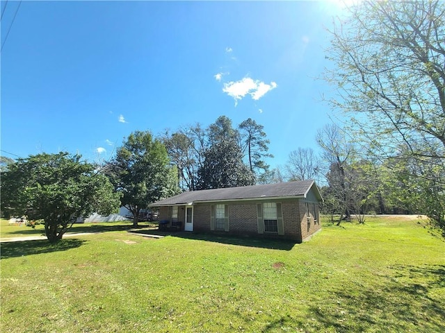 view of front of property featuring brick siding and a front lawn