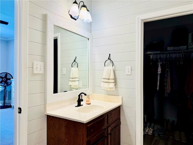 2200 Orourke Dr, Mobile, AL 36695 - bathroom featuring vanity, a walk in closet, and wood walls