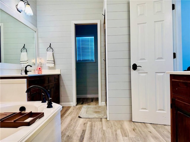 2200 Orourke Dr, Mobile, AL 36695 - bathroom with wood finished floors, vanity, a garden tub, wood walls, and baseboards