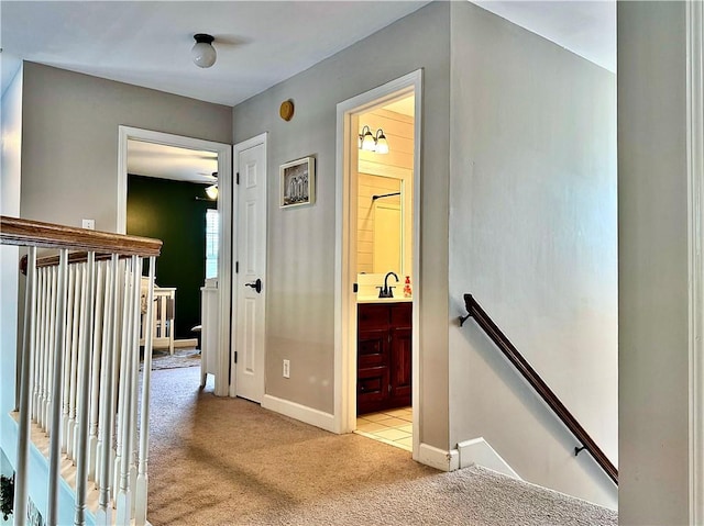2200 Orourke Dr, Mobile, AL 36695 - corridor featuring an upstairs landing, light colored carpet, baseboards, and a sink