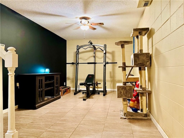 2200 Orourke Dr, Mobile, AL 36695 - workout area with ceiling fan, a textured ceiling, concrete block wall, and tile patterned flooring