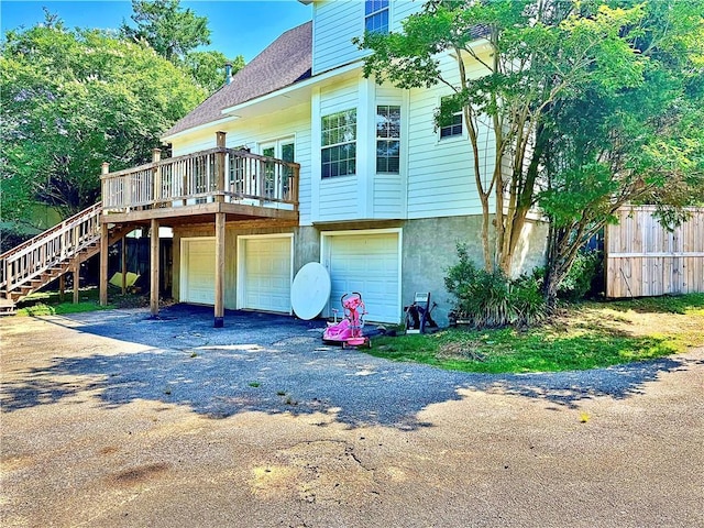 2200 Orourke Dr, Mobile, AL 36695 - back of property featuring a deck, an attached garage, stairway, asphalt driveway, and roof with shingles