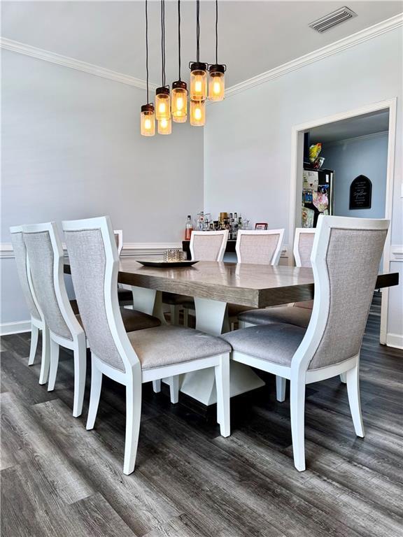 2200 Orourke Dr, Mobile, AL 36695 - dining area featuring crown molding, dark wood-style floors, and baseboards