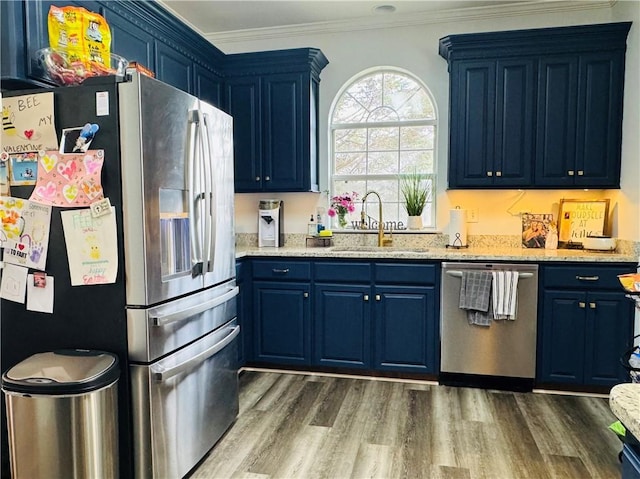 2200 Orourke Dr, Mobile, AL 36695 - kitchen with stainless steel appliances, blue cabinetry, a sink, wood finished floors, and ornamental molding