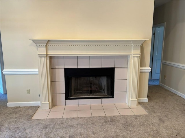 interior details with baseboards, a tile fireplace, and carpet flooring
