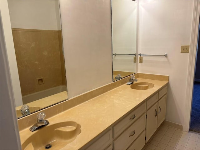 full bathroom with double vanity, a sink, and tile patterned floors