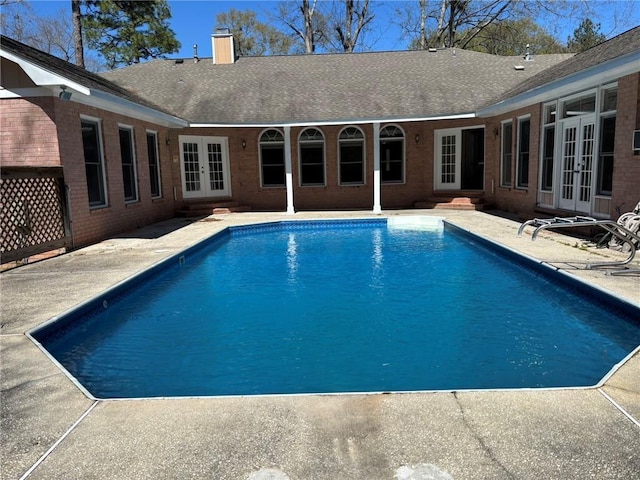 outdoor pool featuring a patio, french doors, and entry steps