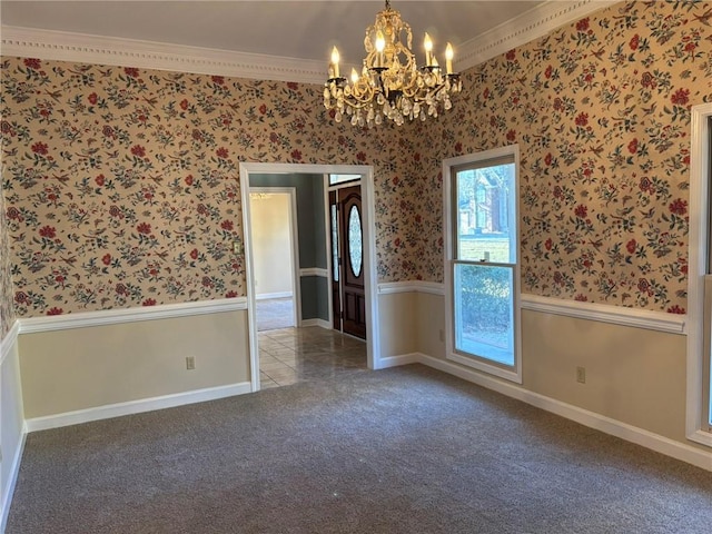 empty room featuring crown molding, wallpapered walls, carpet floors, a notable chandelier, and wainscoting