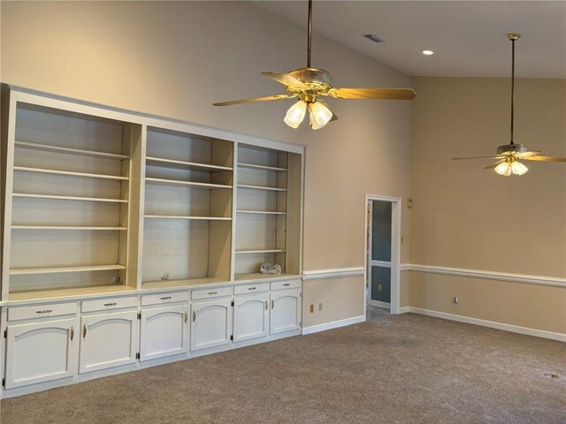 interior space featuring baseboards, high vaulted ceiling, carpet, and a ceiling fan