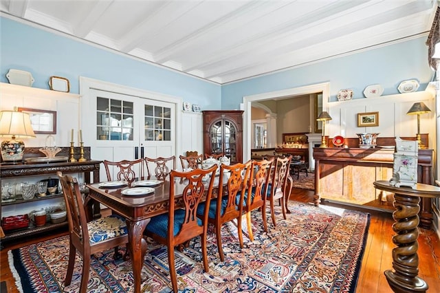 26 Julia St S, Mobile, AL 36604 - dining room featuring ornate columns, wood finished floors, arched walkways, and beamed ceiling