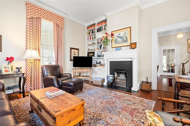 26 Julia St S, Mobile, AL 36604 - living room featuring wood-type flooring, crown molding, a fireplace with flush hearth, and built in shelves