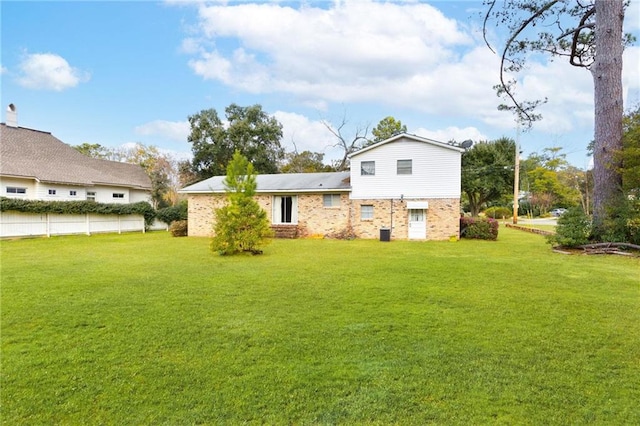 rear view of property featuring a lawn