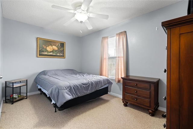 carpeted bedroom featuring ceiling fan and a textured ceiling