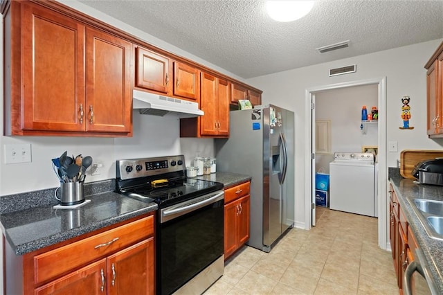 kitchen with light tile patterned floors, sink, stainless steel appliances, a textured ceiling, and washer / clothes dryer