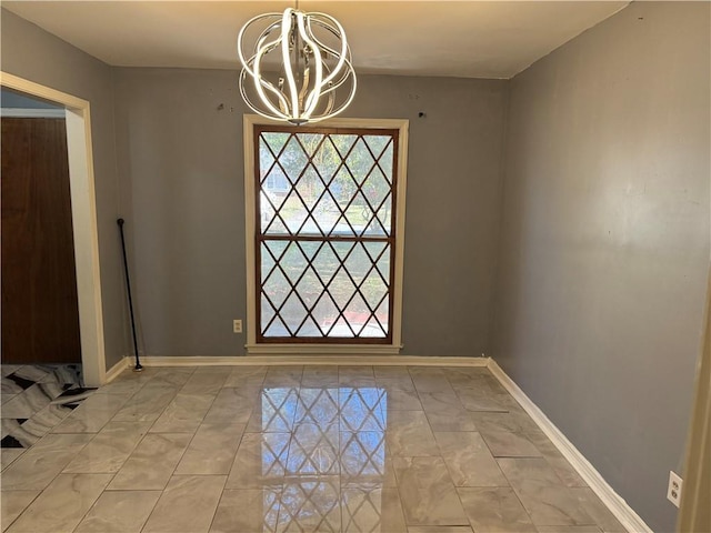 interior space featuring baseboards and a chandelier