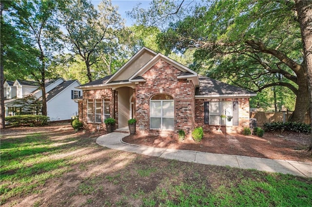 traditional-style house featuring fence and brick siding