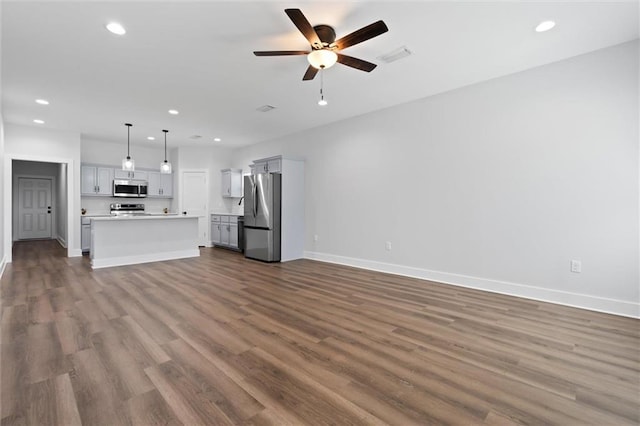 unfurnished living room with ceiling fan and hardwood / wood-style floors