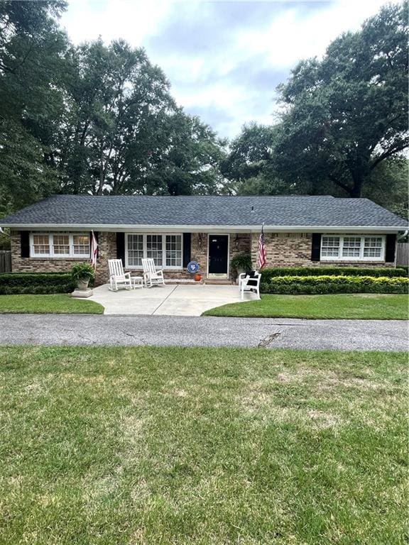 ranch-style house with a front yard and a patio area