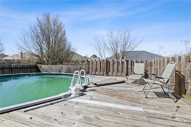 view of swimming pool with a fenced backyard, a deck, and a fenced in pool