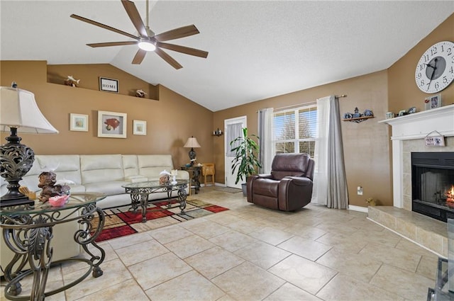 living area featuring a fireplace, vaulted ceiling, ceiling fan, baseboards, and tile patterned floors