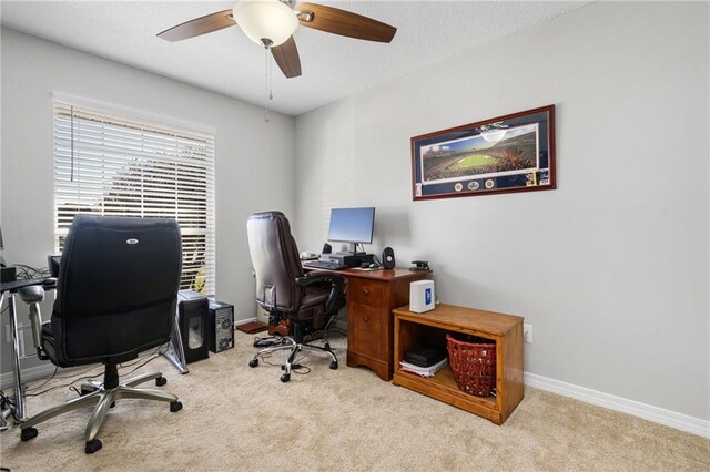 home office featuring carpet floors, a ceiling fan, and baseboards