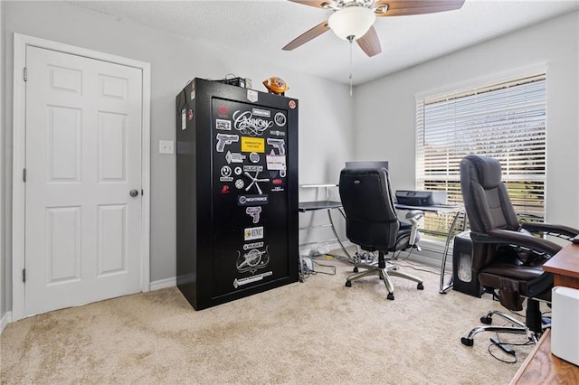 home office with carpet, ceiling fan, and a textured ceiling