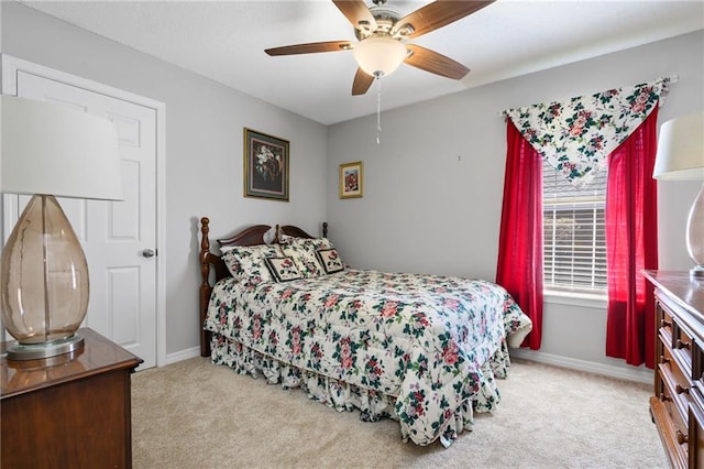 bedroom with light colored carpet, ceiling fan, and baseboards