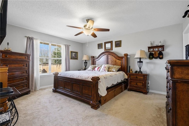 bedroom with baseboards, ceiling fan, a textured ceiling, and light colored carpet