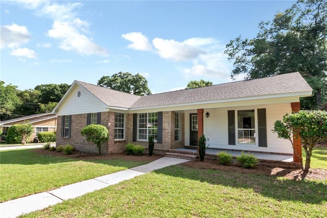 ranch-style house with a front yard, covered porch, and brick siding