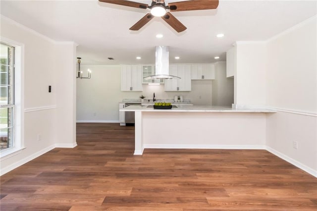 kitchen featuring island exhaust hood, white cabinetry, light countertops, a sink, and recessed lighting