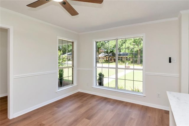unfurnished dining area with wood finished floors, ceiling fan, baseboards, and ornamental molding