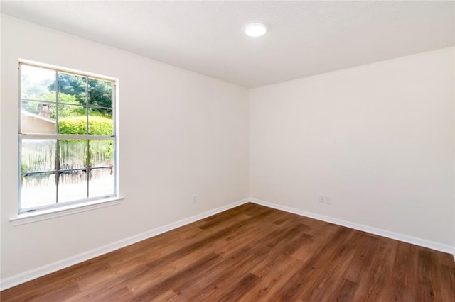 unfurnished room with wood finished floors, baseboards, and recessed lighting