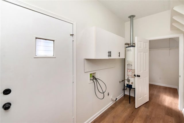 laundry room with hookup for a washing machine, gas water heater, wood finished floors, and baseboards