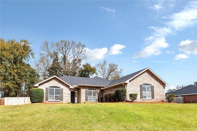 single story home featuring brick siding, a front yard, and fence