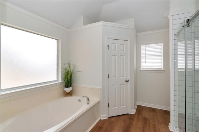 bathroom featuring baseboards, vaulted ceiling, ornamental molding, wood finished floors, and a bath