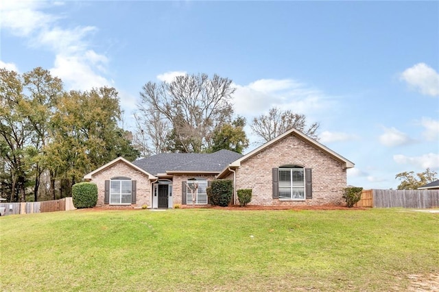 ranch-style home featuring brick siding, a front lawn, and fence