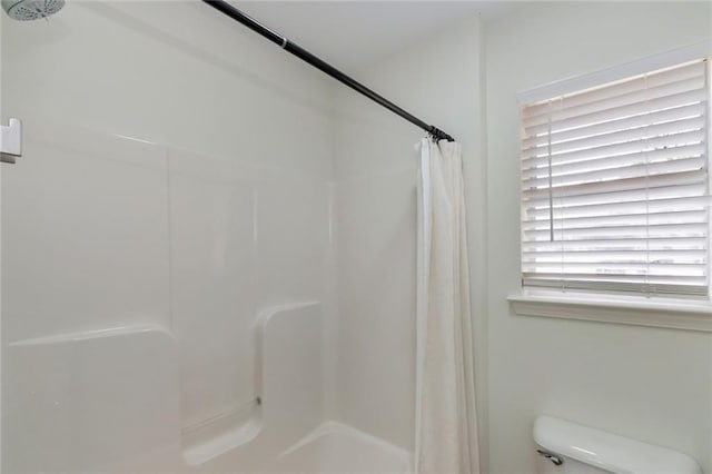 full bathroom with toilet and a shower with curtain