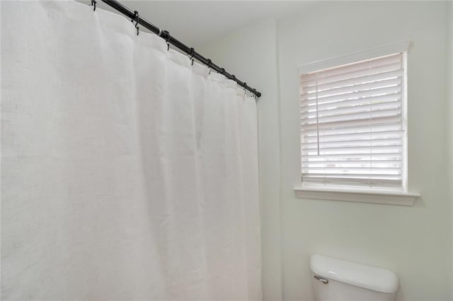 bathroom featuring toilet and a shower with shower curtain