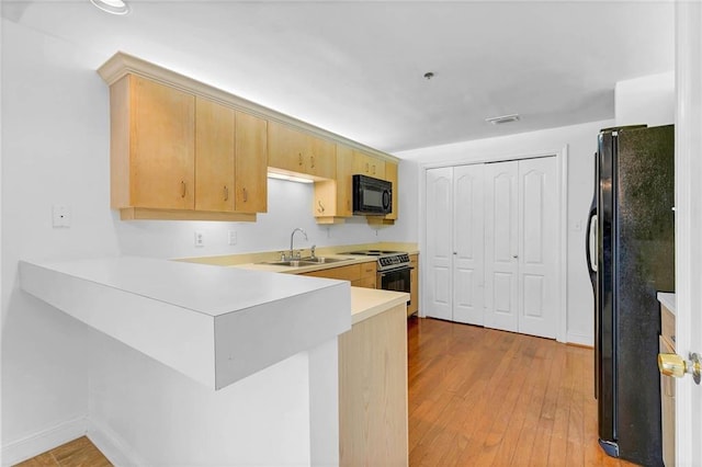 100 Tower Dr Unit 704, Daphne, AL 36526 - kitchen featuring black appliances, a peninsula, light countertops, light wood finished floors, and light brown cabinetry