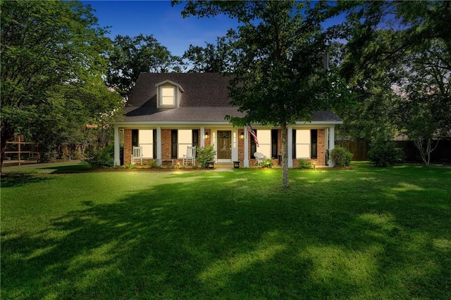 view of front of house with fence, covered porch, and a front yard