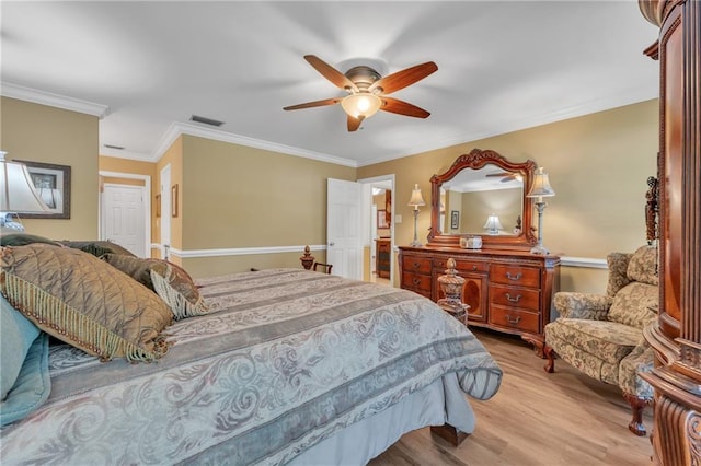 bedroom with visible vents, light wood-type flooring, crown molding, and a ceiling fan