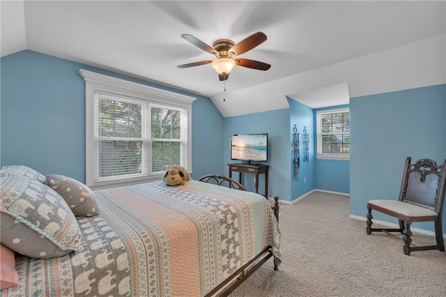 carpeted bedroom with multiple windows, vaulted ceiling, and baseboards