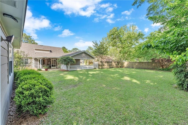view of yard featuring a fenced backyard and a sunroom