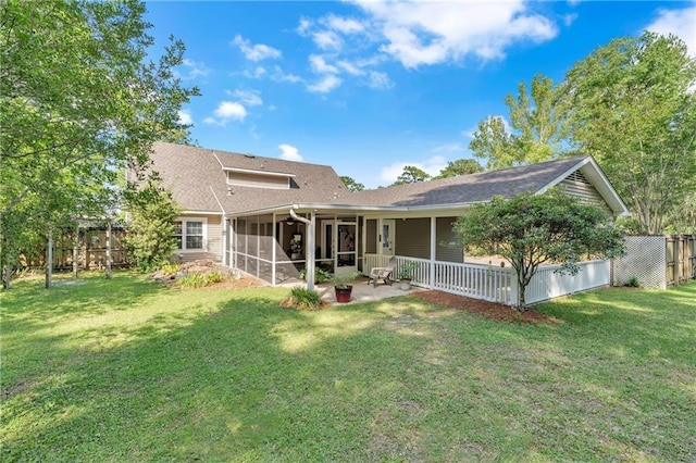 back of property with a patio, fence, a yard, and a sunroom