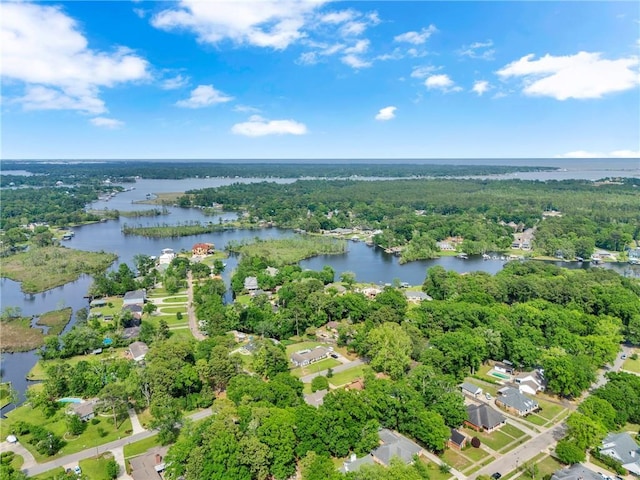 birds eye view of property featuring a water view and a wooded view