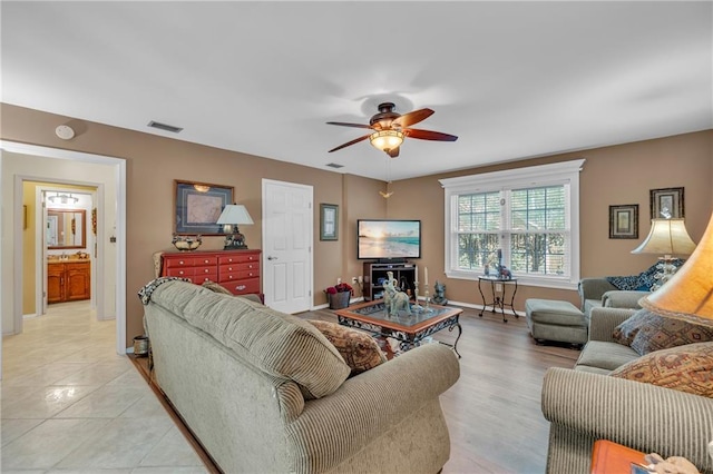 living area with visible vents, ceiling fan, and baseboards