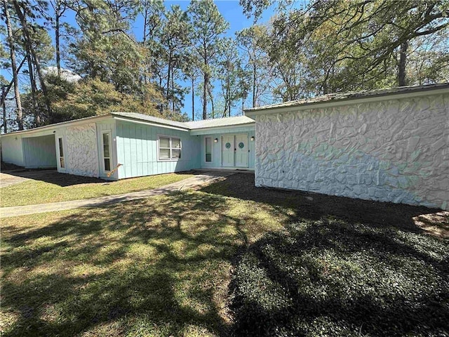 view of front of property with an attached carport and a front lawn